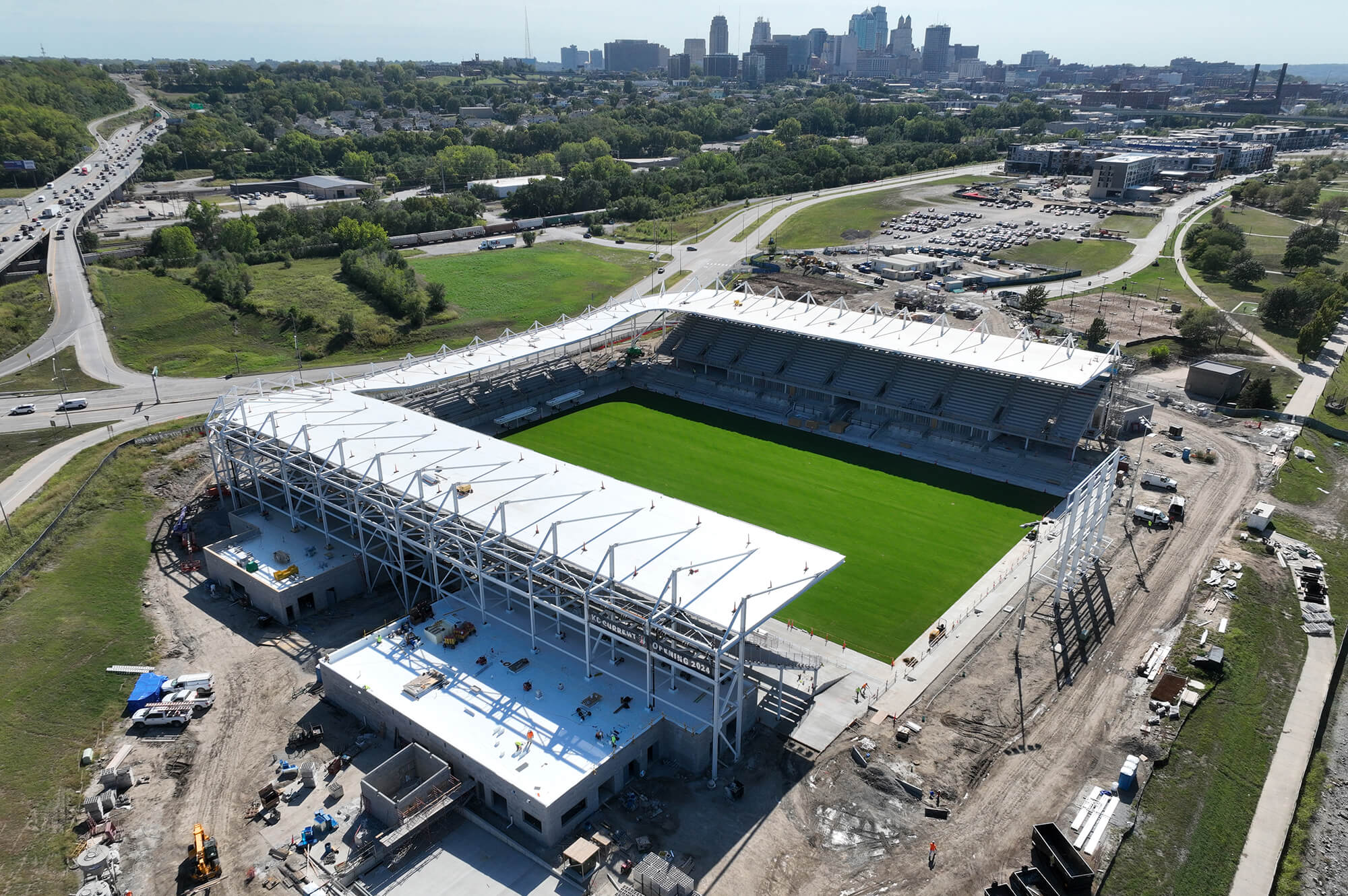 Aerial of CPKC Stadium, green field, parking, river, bridge.