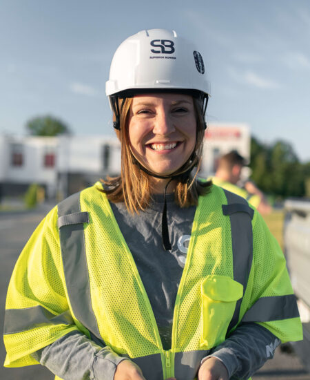 Woman in safety vest and white helmet