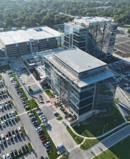 Aerial view of glass office buildings, parking lots, and greenery.