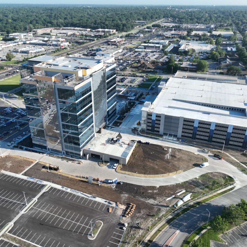 Aerial view of office building and parking garage under construction.