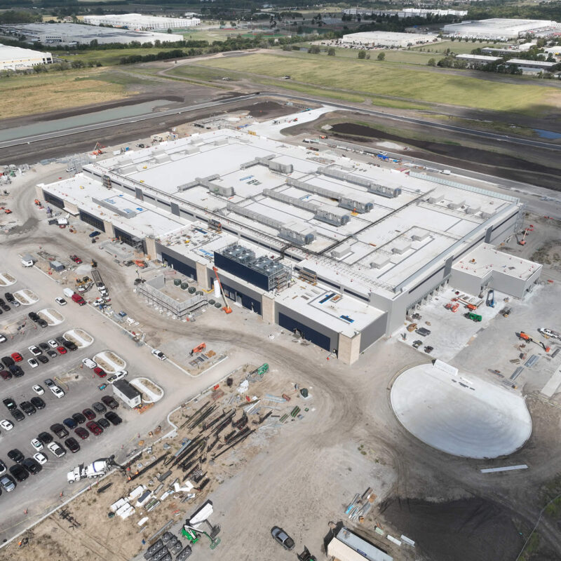 Aerial view of an industrial building under construction and surroundings.