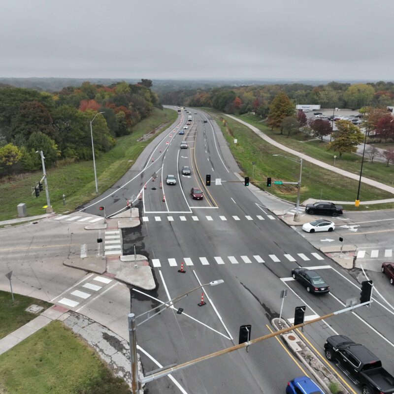 Multi-lane intersection, traffic lights, cones, Walmart on right.
