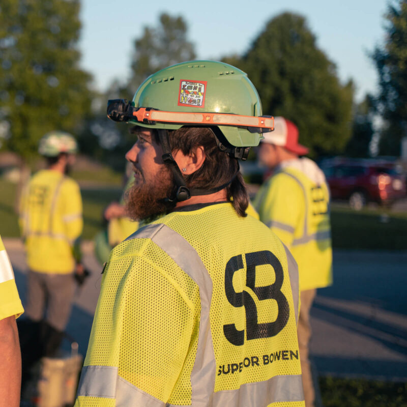 Worker in yellow vest and helmet, Superior Bowen logo visible.
