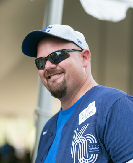 Smiling man in Royals gear with “Jonathan” name tag outdoors.