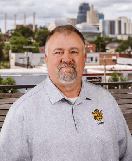Man with gray hair and goatee in Mizzou polo outdoors.